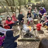 A group round the firepit at the forest school