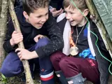 Two boys hiding in a den at the forest school